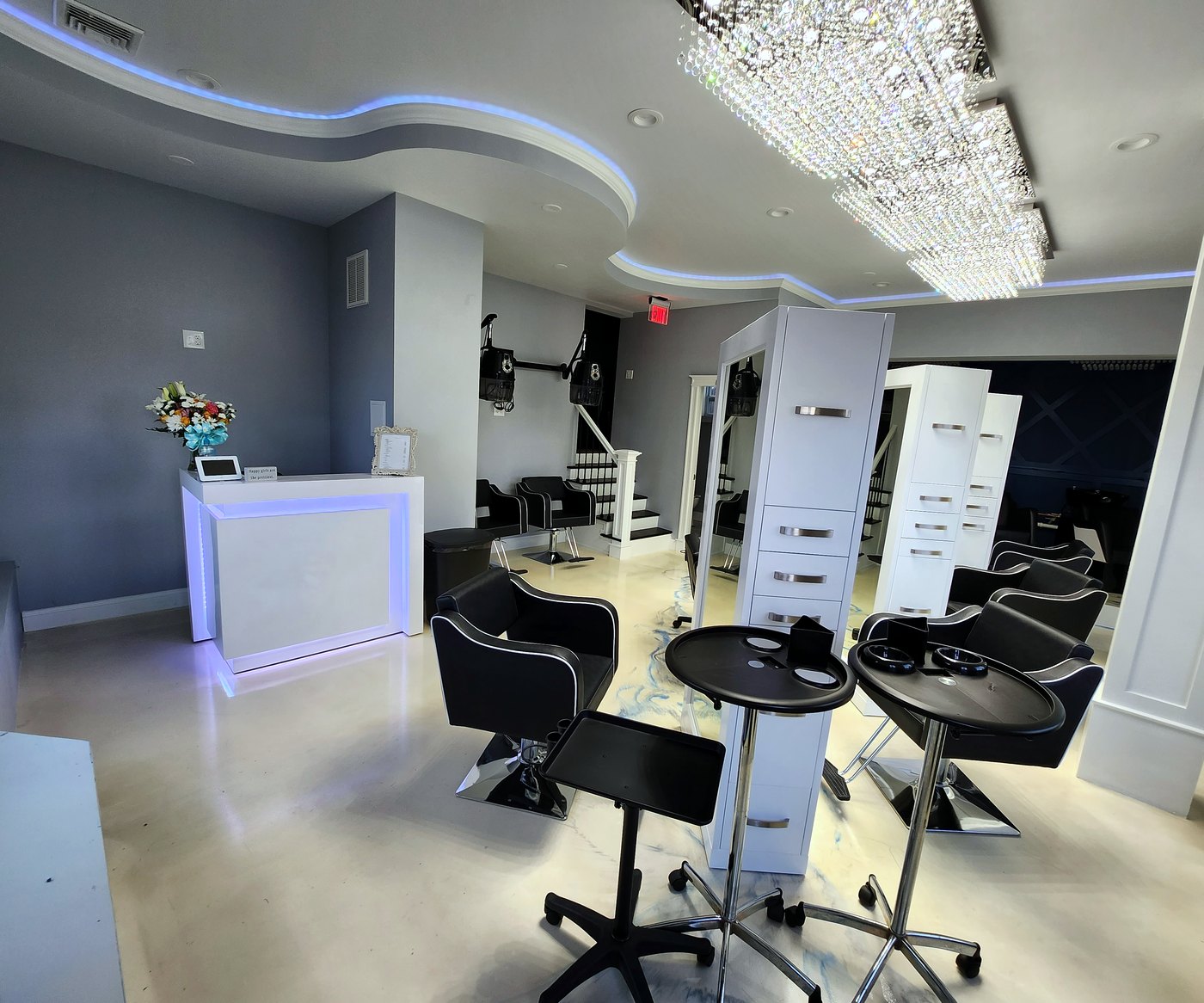 A Hair Story Salon interior, reception desk and styling stations with crystal chandelier in Fall River MA